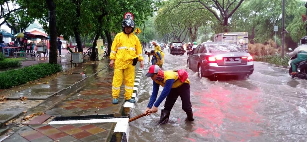 Petugas kebersihan Pemkot Tangerang membersihkan saluran gorong-gorong yang mampet.