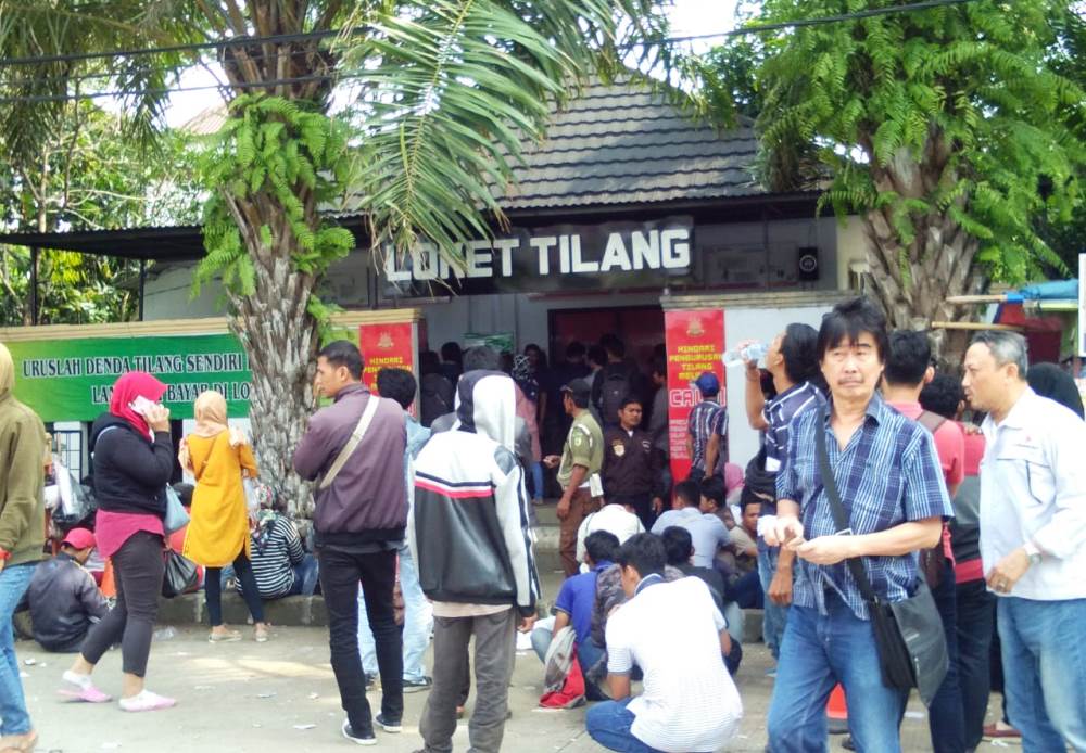Suasana masyarakat yang ingin mengambil STNK kendaraannya saat mengantri di loket layanan di Tigaraksa, Kabupaten Tangerang, Selasa (27/11/2018).