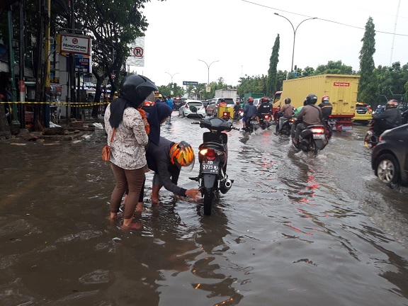 Tampak seorang pengendara motor mengalami mogok kendaraannya akibat melewati banjir di jalan MH Thamrin Cikokol tepatnya di dekat Carrefour.