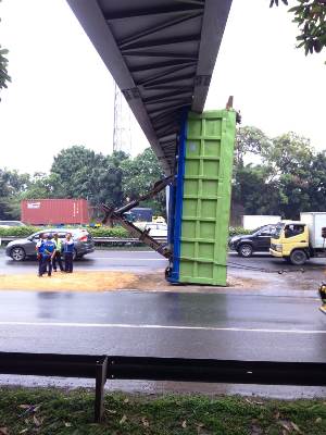 Tampak bak truk menabrak dan tersangkut di jembatan penyeberangan orang (JPO) di KM 23.300 Tol Karawaci, Kabupaten Tangerang, Senin (14/1/2019).