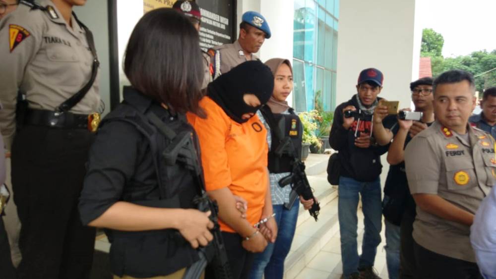 Tersangka Lilis Siti Saadah, 20, (berpakaian oranye) tertunduk menyesali perbuatannya yang tega telah membunuh sang buah hatinya.