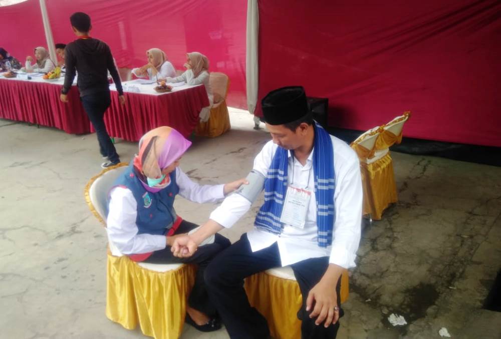 Tampak petugas kesehatan sedang memberikan bantuan medis kepada petugas TPS.