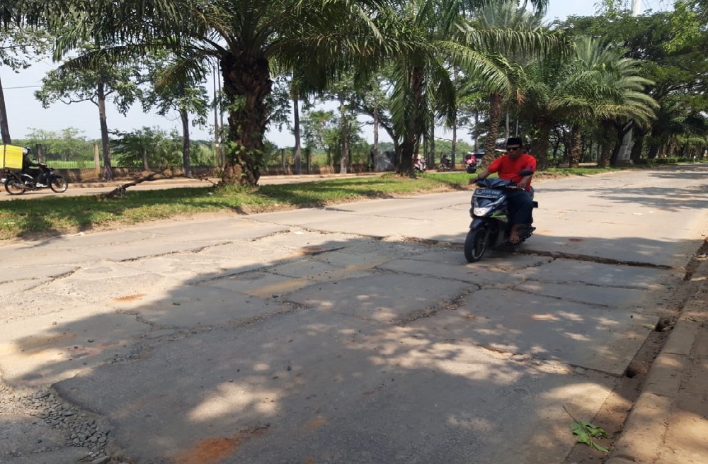Terlihat Jalan Juanda di Neglasari, Kota Tangerang rusak parah membuat pengendara khususnya sepeda motor berhati - hati saat melewatinya.
