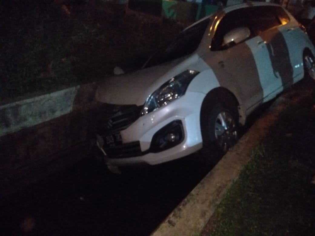 Tampak mobil Suzuki Ertiga warna putih terperosok ke dalam selokan di Perumahan Villa Dago, Pamulang, Kota Tangsel.