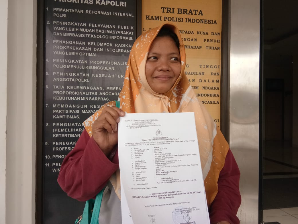 Rumini, 44, saat menunjukan surat dari Kepolisian bahwa laporannya telah diterima terkait dugaan pungutan liar (pungli) di SDN Pondok Pucung 02, Pondok Aren, Tangsel.
