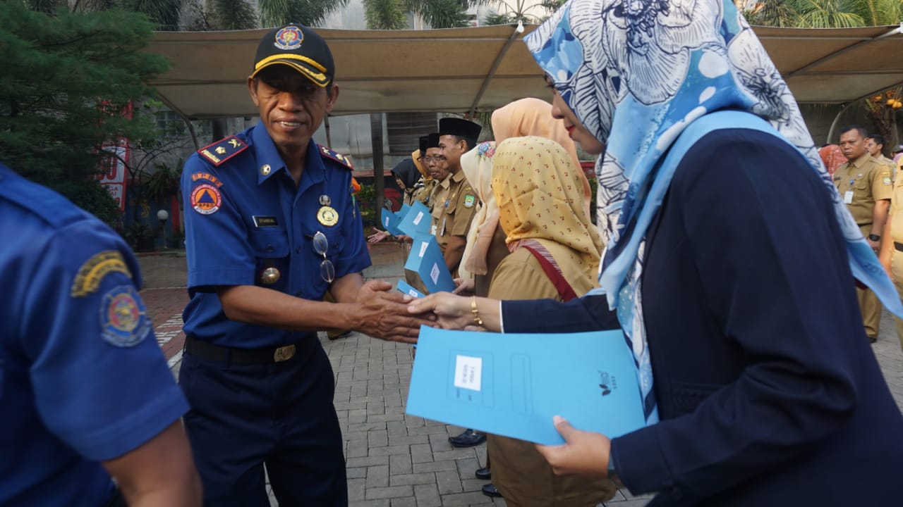 Camat Periuk Sumardi dan Kepala UPT Damkar Periuk Syahrial saat menyerahkan piagam penghargaan kepada 15 kepala SD di halaman kantor Kecamatan Periuk, Kota Tangerang, Senin (8/7/2019).