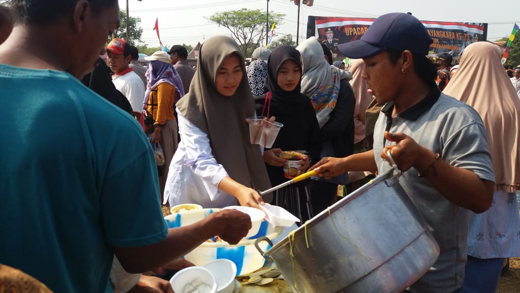 Suasana masyarakat yang ikut makan gratis pada Perayaan HUT Bhayangkara ke-73, di Lapangan Nunggul, Kelurahan Sukatani, Kecamatan Rajeg, Rabu (10/7/2019).