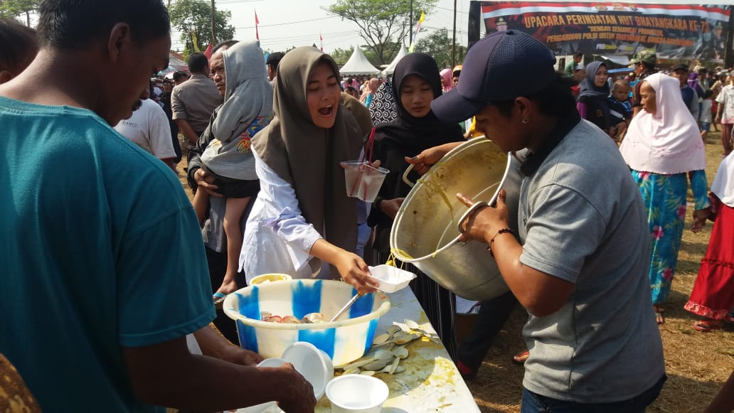 Suasana masyarakat yang ikut makan gratis pada Perayaan HUT Bhayangkara ke-73, di Lapangan Nunggul, Kelurahan Sukatani, Kecamatan Rajeg, Rabu (10/7/2019).