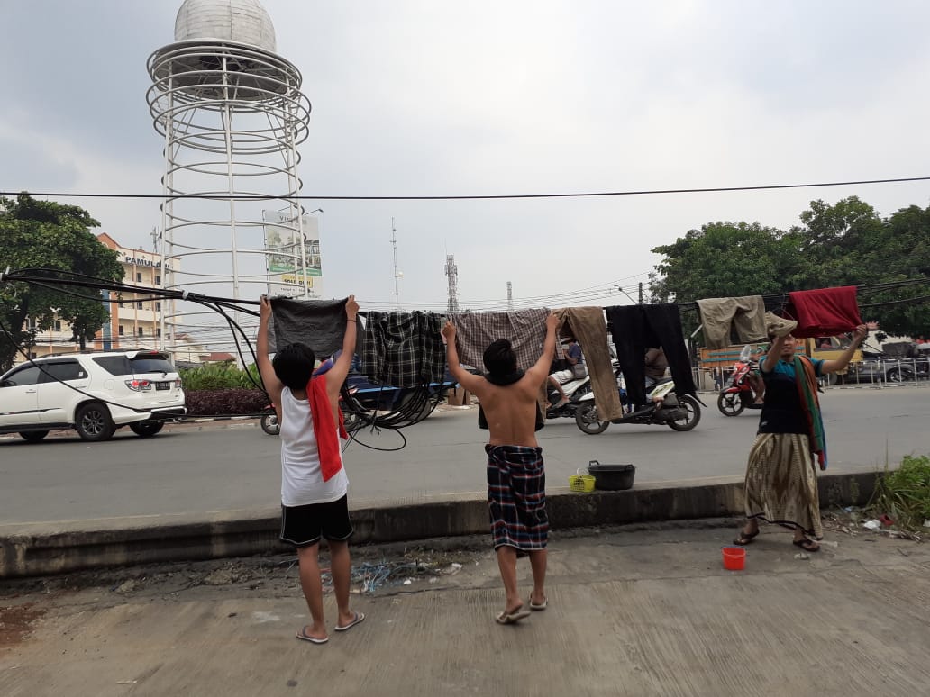 Tampak warga menjemur pakaian di kabel listrik didekat Bunderan Pamulang, Jalan Siliwangi, Pamulang, Tangerang Selatan, Senin (15/7/2019).