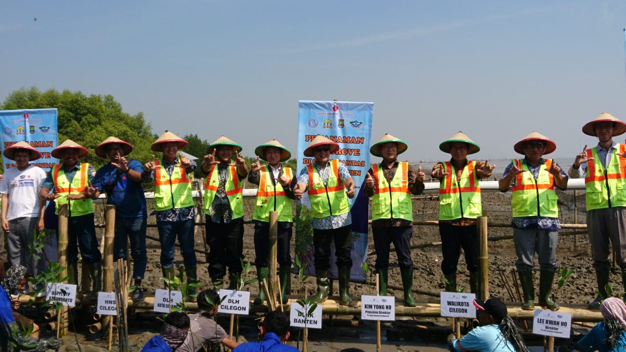 Presidem Ditektur PT Lotte Chemical Indonesia Kim Yong Ho saat menanam bibit pohon mangrove di sekitar pesisir pantai.