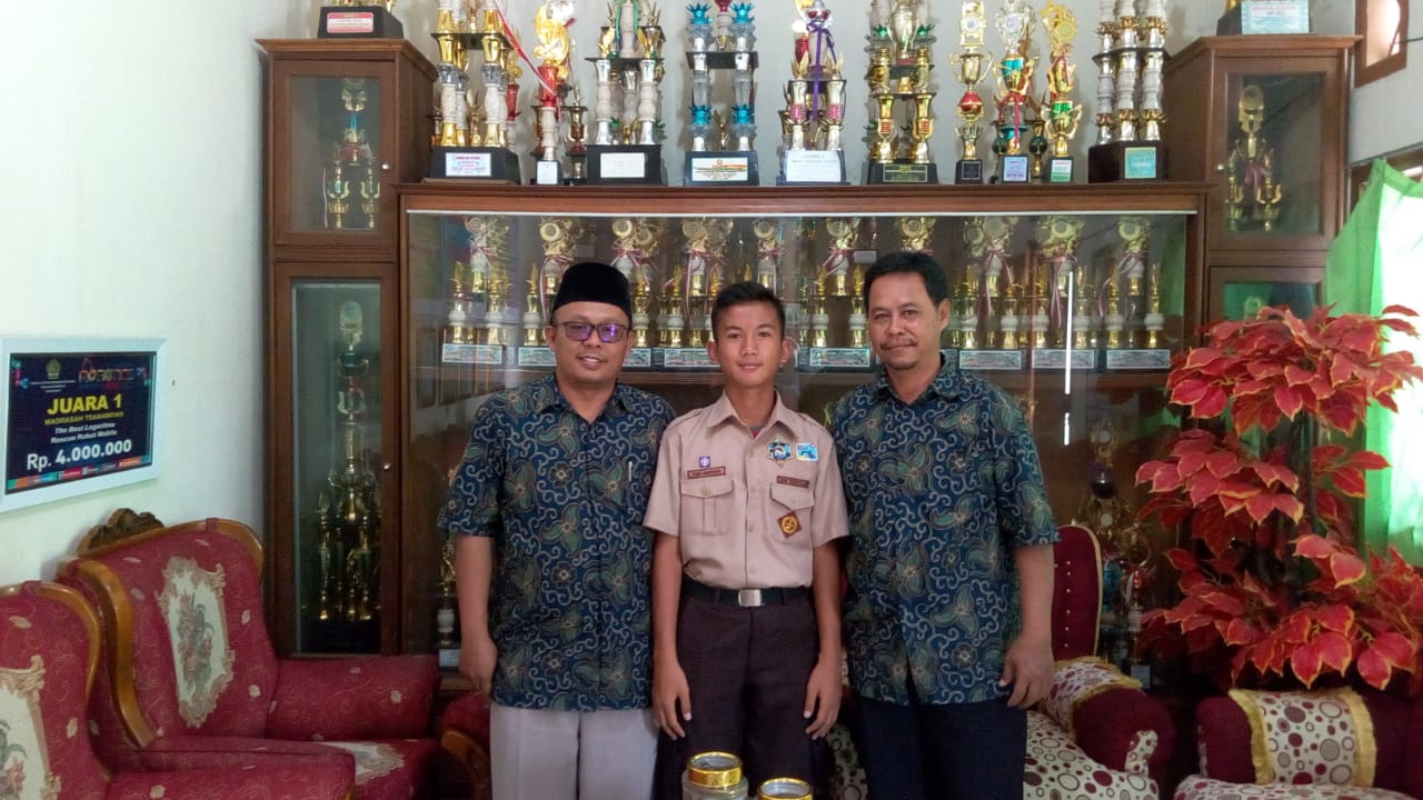 Adam Nugraha, 13, pesebakbola Junior Kabupaten Tangerang bersama kedua orang tuanya.
