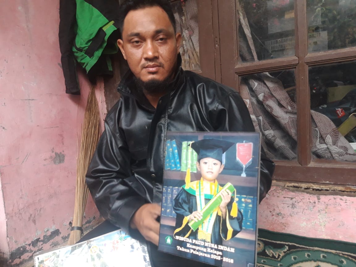 Supriyadi, paman Husein, 8 tahun, saat menunjukan foto almarhum yang tenggelam di Sungai Cisadane.