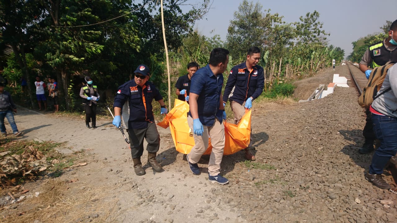 Polisi dibantu warga saat mengevakuasi mayat tanpa identitas di dekat rel kereta api, Cibeber, Kota Cilegon.