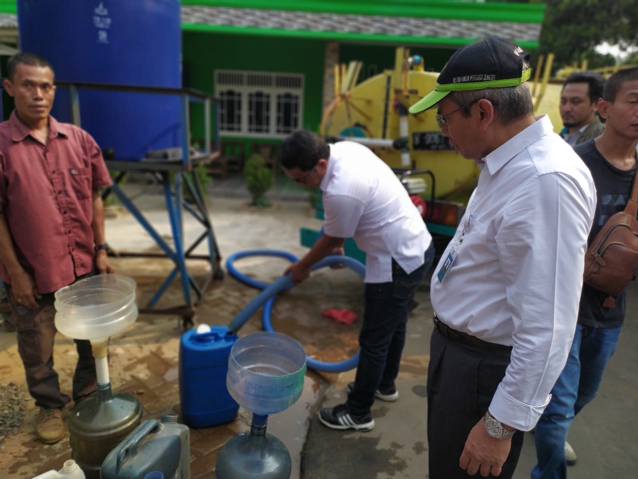 Direktur Utama PT PITS Dudung E Diredja (mengenakan kemeja putih memakai topi) saat memberikan bantuan air bersih kepada warga Koceak.