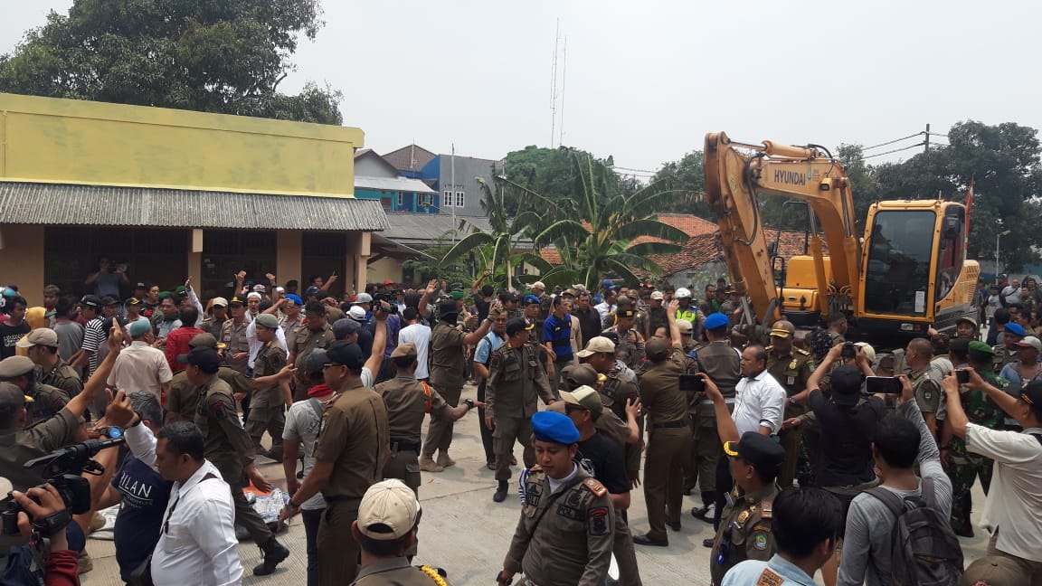 Tampak terjadi bentrokan antara warga dengan Petugas Satpol PP di eksekusi penggusuran Makam Wareng di Koang Jaya, Karawaci, Kota Tangerang menggunakan alat berat beko.