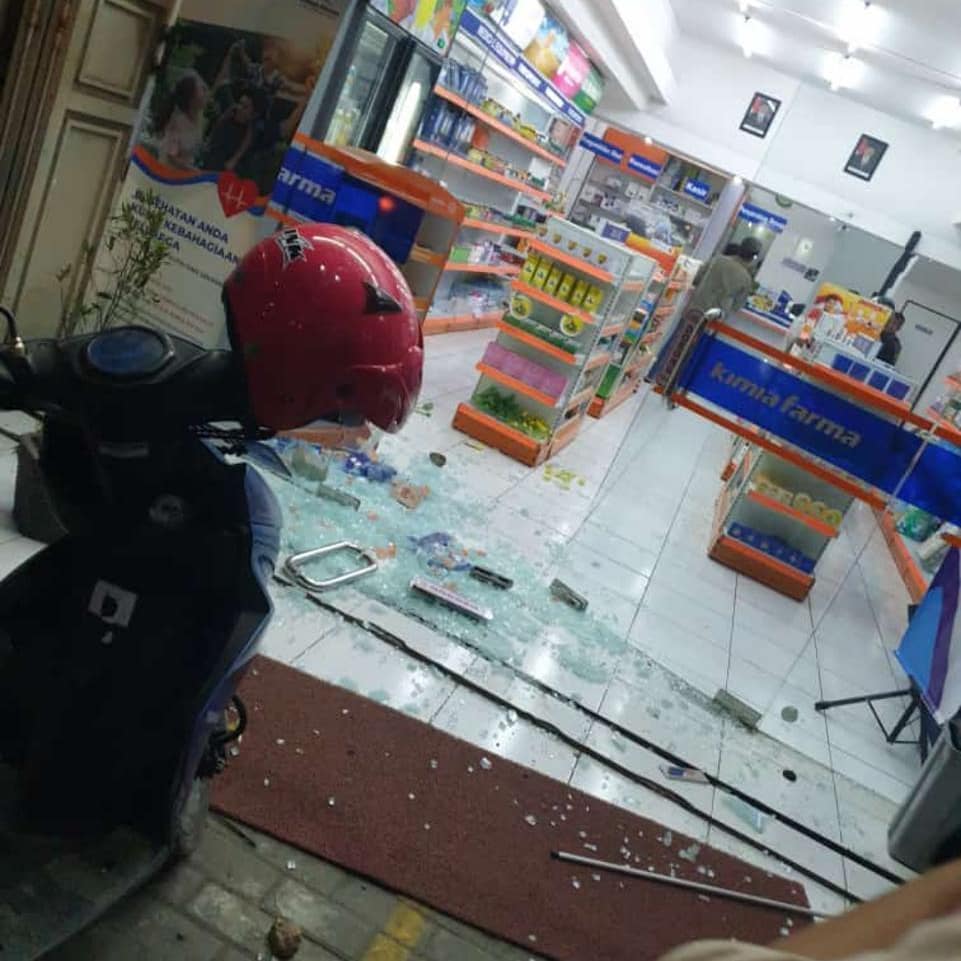 Polisi meninjau toko obat yang dilempari batu oleh oknum dari suporter Perserang dan Cilegon United yang menyebabkan pintu kaca toko pecah di jalan protokol Kota Cilegon.