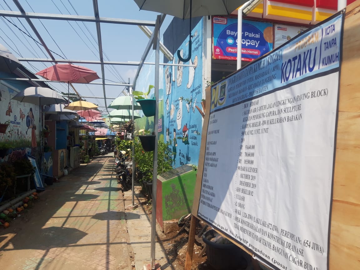 Papan proyek pengerjaan drainase lingkungan dalam program Kotaku di Kampung Bekelir, Senin (4/11/2019).