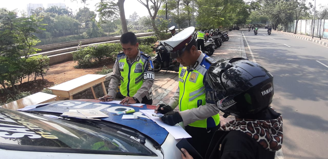 Terlihat Polisi saat menilang pengguna jalan yang tidak melengkapi surat-surat kendaraannya.