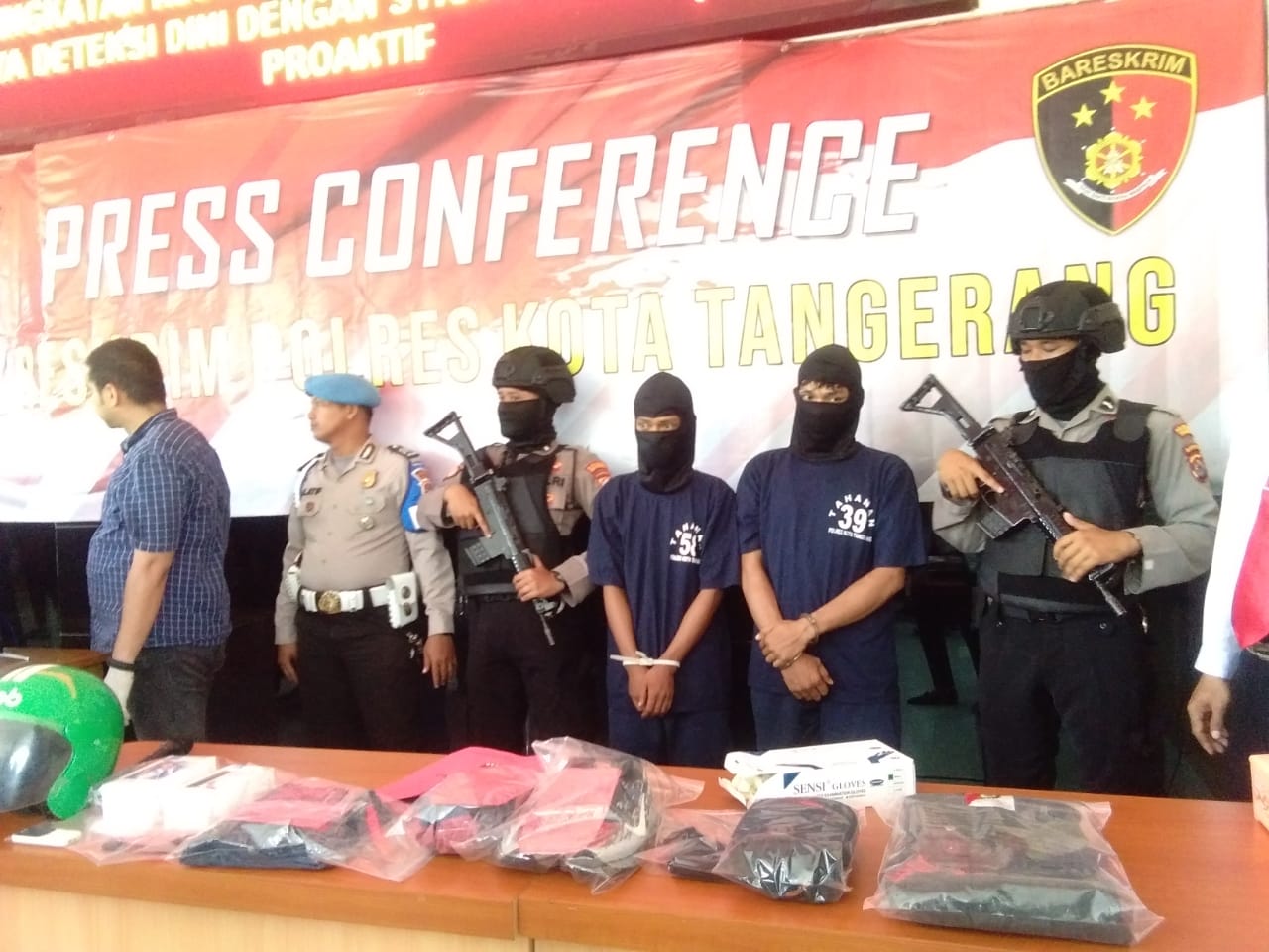 Para tersangka berinisial M, 27, dan S, 27, pelaku perampokan di Alfamart Cikupa, mengenakan pakaian tahanan Polisi .