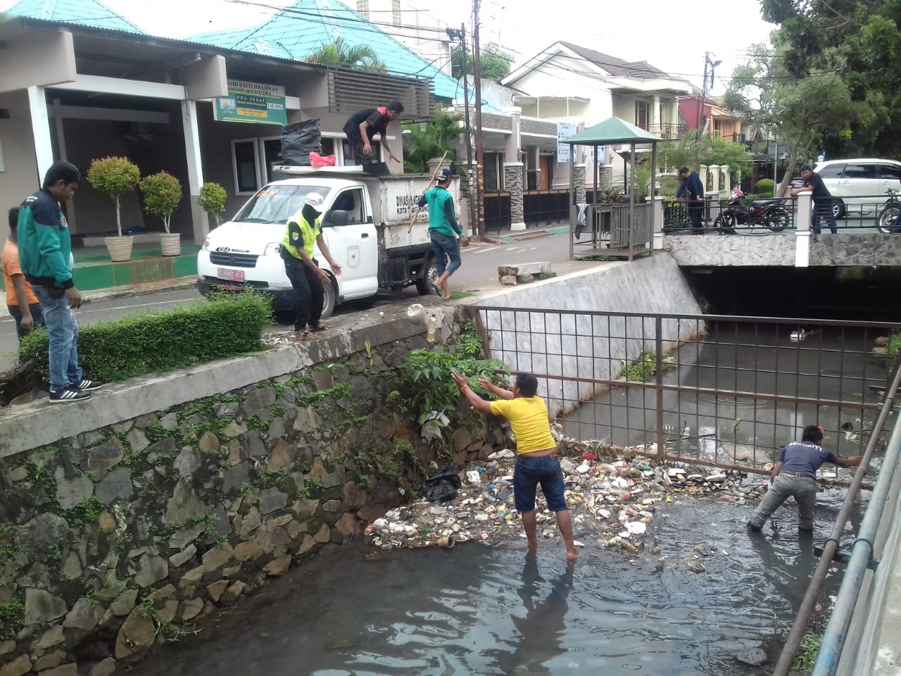 Tampak para petugas dari Dinas Lingkungan Hidup (DLH) Kota Tangsel saat membersihkan sampah di irigasi perumahan sekitar Tangsel.