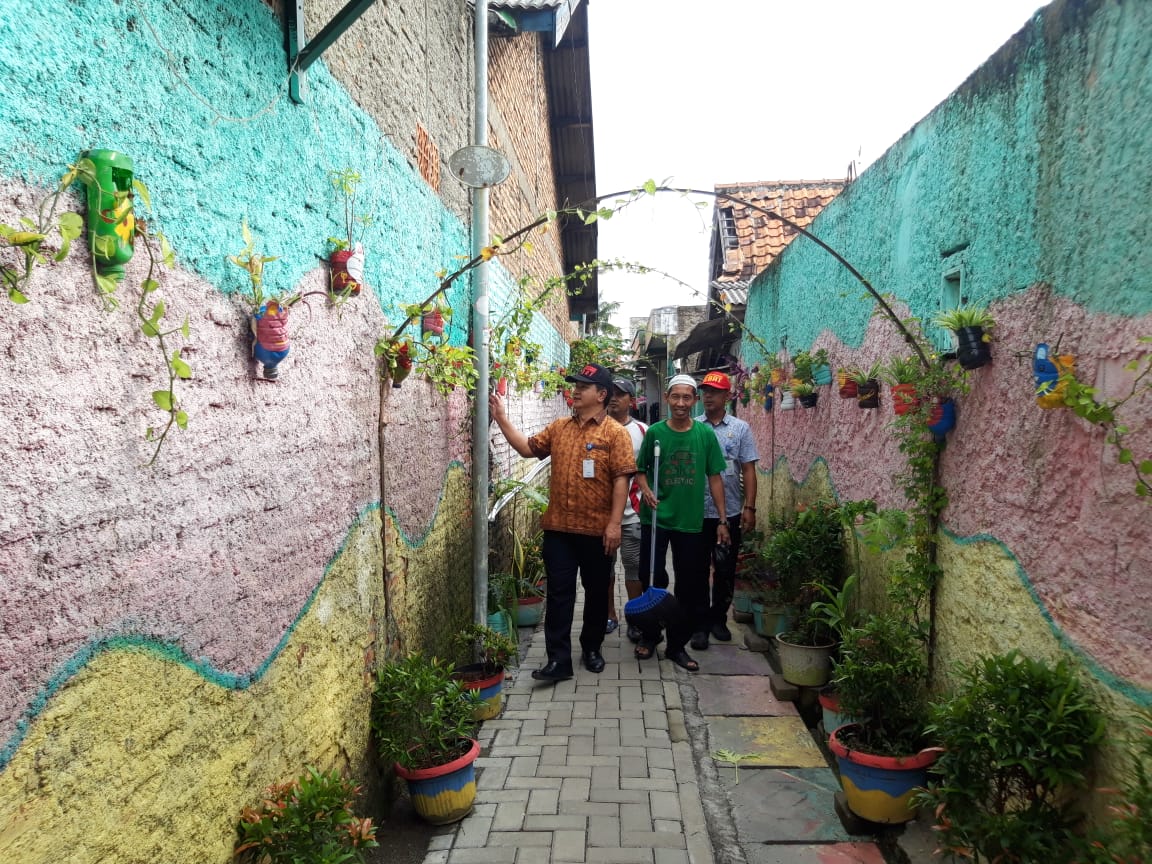 	Lurah Karang Sari Iwan Mulyawan berswafoto di mural bermotif sayap di area Kampung Bandara, Neglasari, Kota Tangerang.