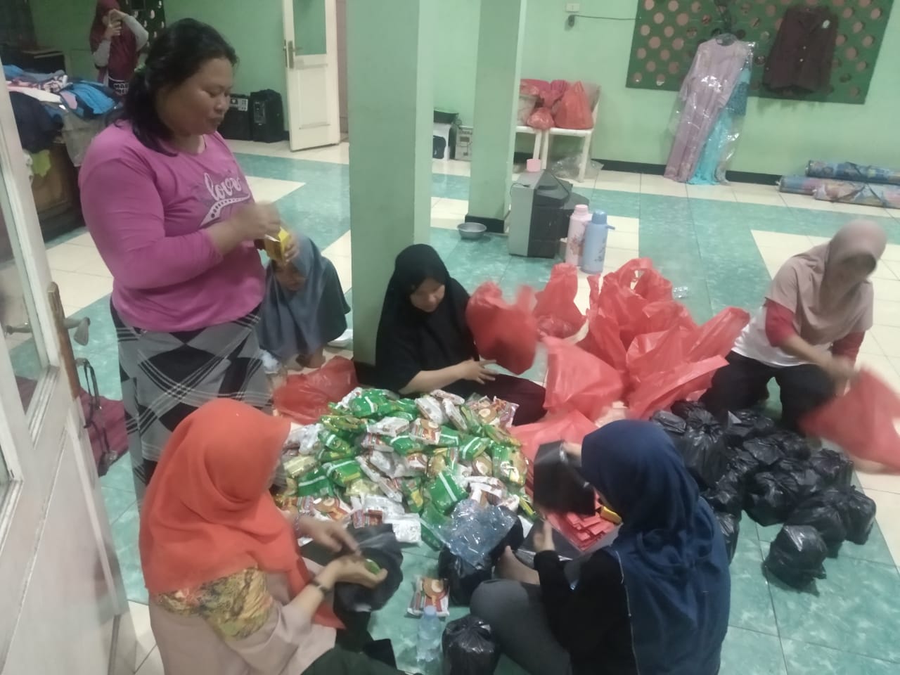 Warga tengah mengemasi bantuan logistik di pengungsian korban banjir Desa Kadu, Kecamatan Curug, Senin (3/2/2020) malam.