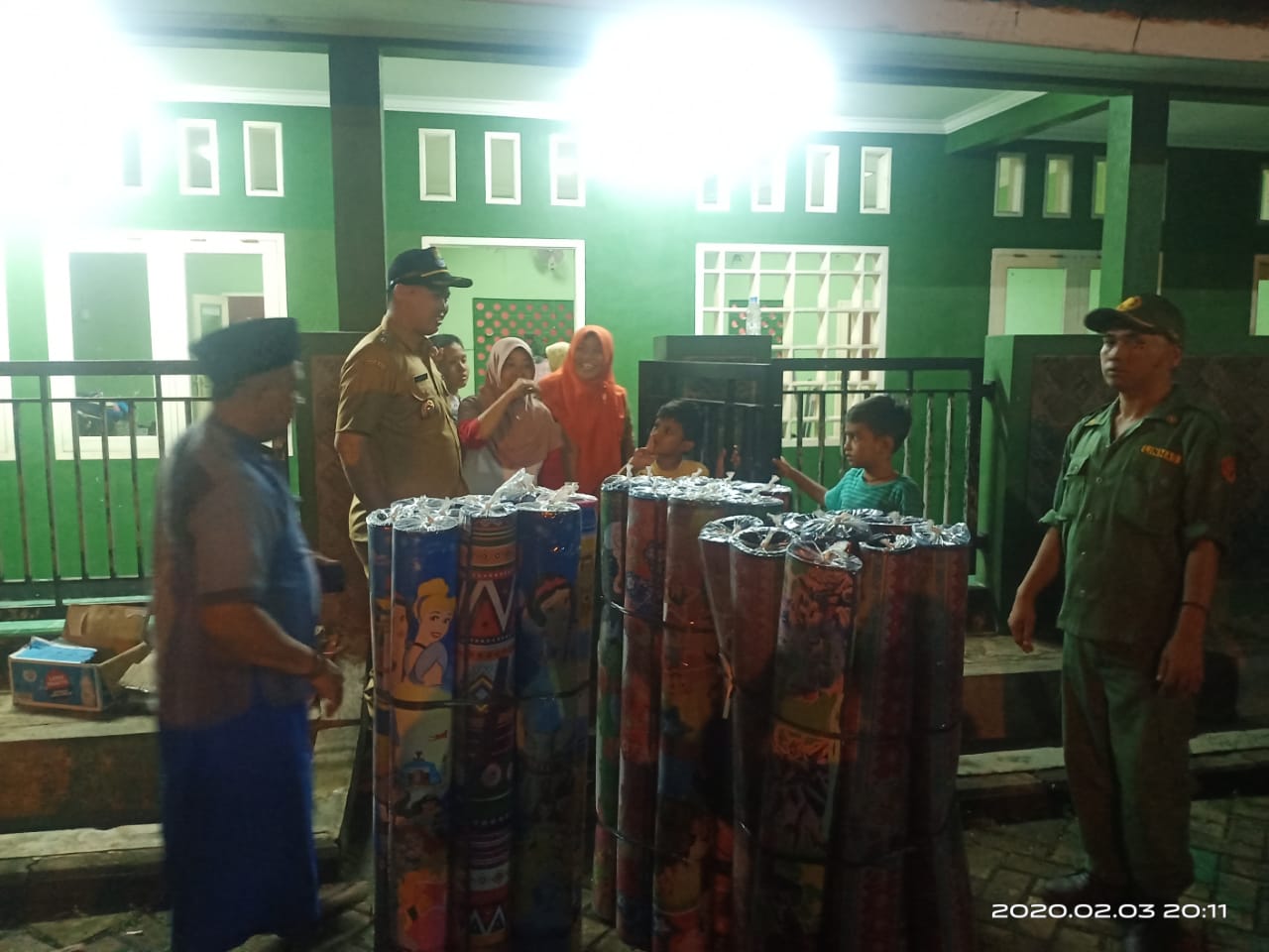 Kepala Desa Kadu Muhamad Asdiansyah (kedua dari kiri) saat menyerahkan logistik untuk korban banjir di tempat pengungsian warga, Senin (3/2/2020) malam.