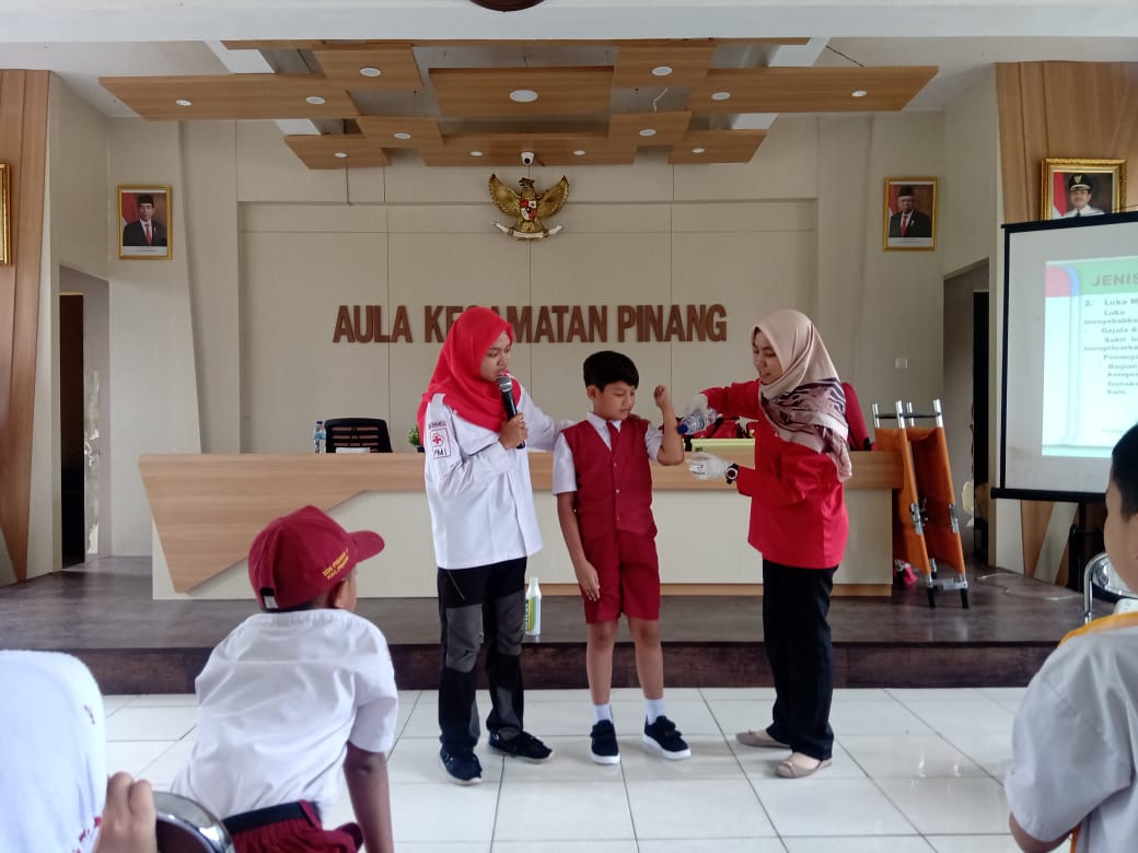 Petugas PMI memberikan contoh praktik pertolongan pertama kepada siswa sekolah dasar dalam pelatihan dokter cilik, Senin (17/2/2020).