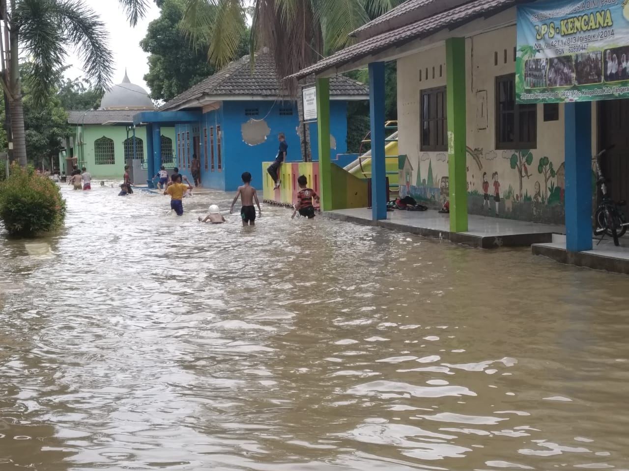 Anak-anak di RW 31 Kelurahan Bencongan, Kecamatan Kelapa Dua sedang berenang saat lokasi tersebut terendam banjir, Selasa (25/2/2020).