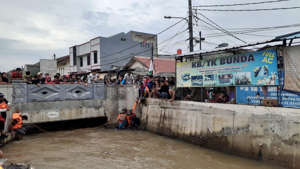 Proses pencarian dua anak kecil yang hanyut dalam derasnya aliran kali Pondok Maharta, Pondok Aren, Tangerang Selatan.