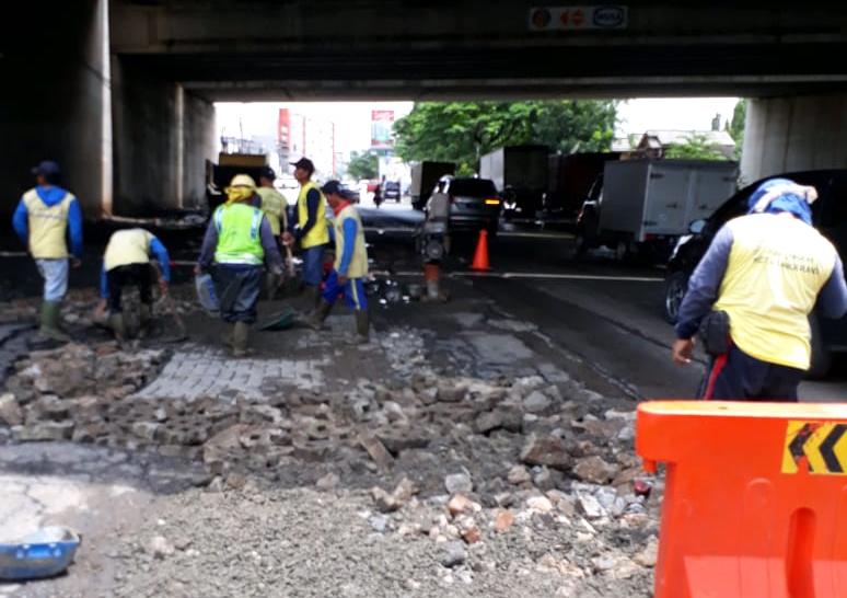 Tampak para pegawai kontruksi sedang memperbaiki jalanan yang rusak di Kota Tangerang.