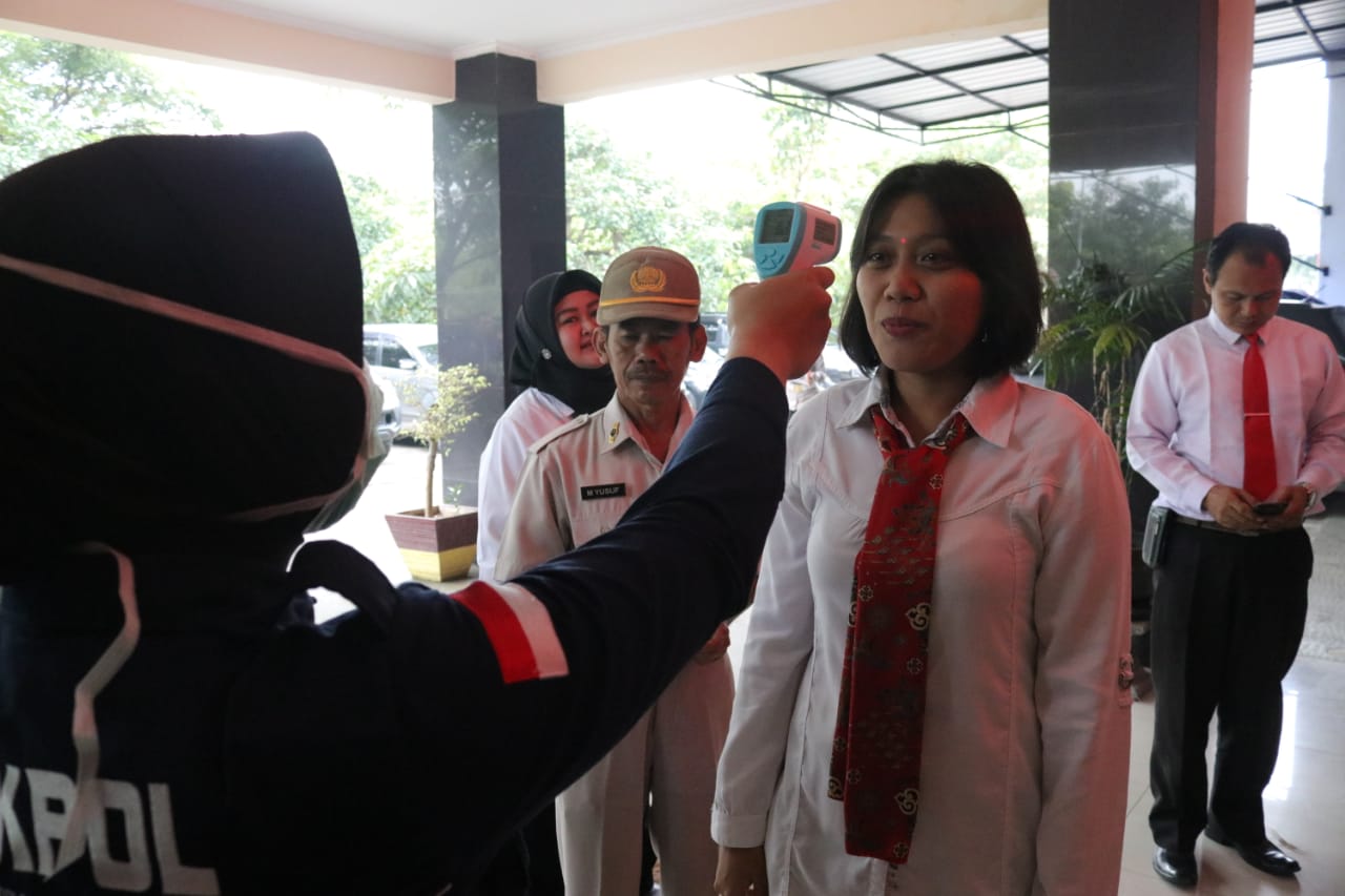 Personel Polresta Tangerang saat melakukan pengukuran suhu tubuh di kantor Polresta Tangerang, Senin (16/3/2020).