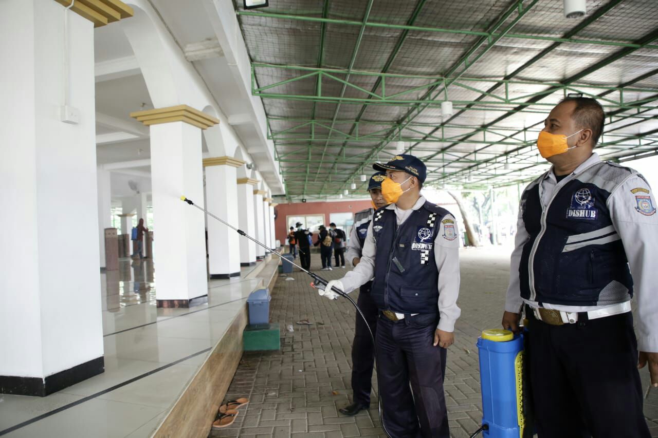 Petugas saat melakukan strerilisasi disinfektan di rumah ibadah,