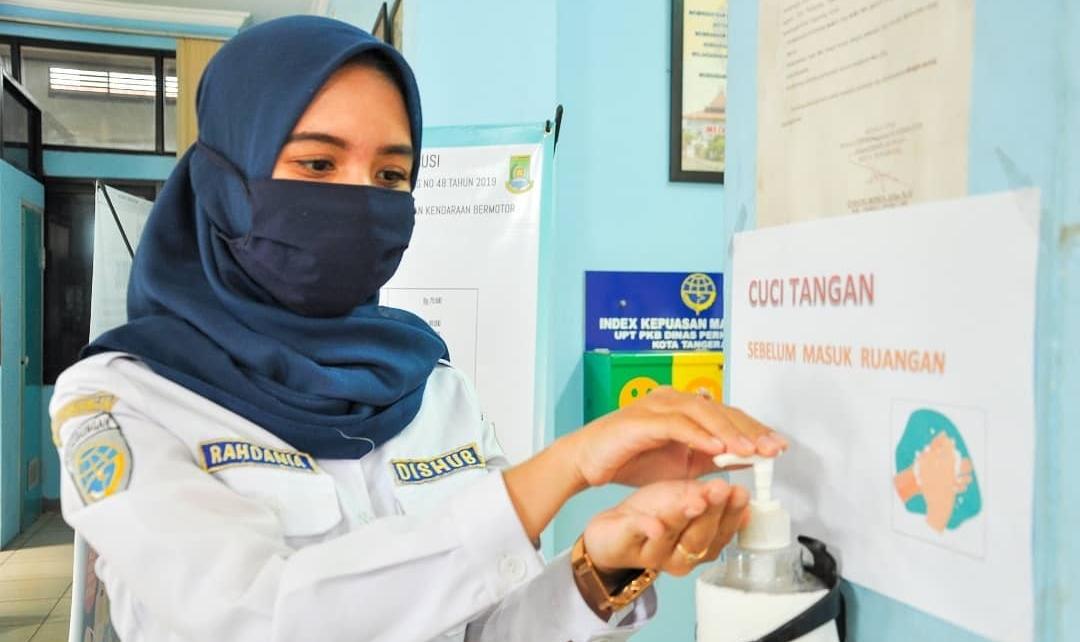Petugas saat mengenakan masker dan menyediakan hand sanitizer di UPT Pengujian Kendaraan Bermotor (PKB) atau UPT KIR Batuceper, Kota Tangerang.