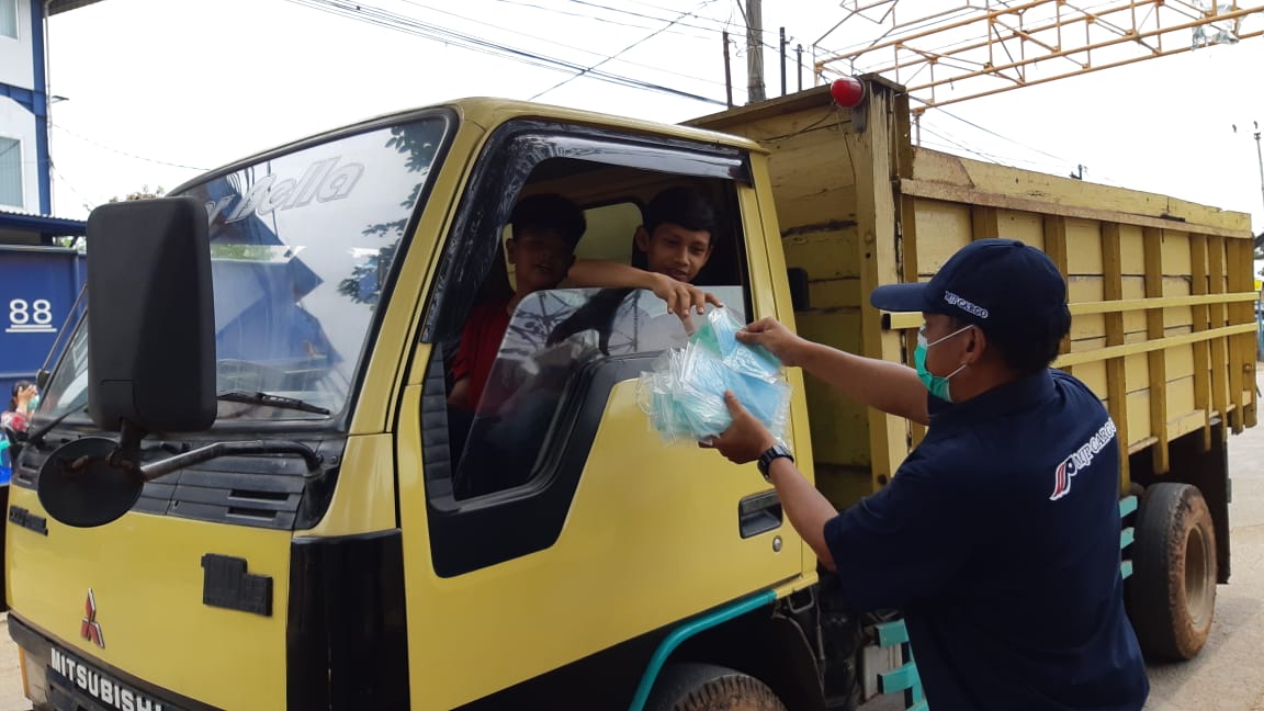 Petugas MJP Cargo membagikan masker gratis kepada masyarakat.