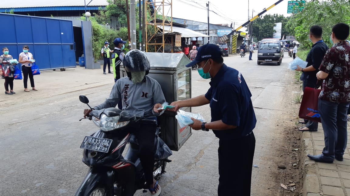 Petugas MJP Cargo membagikan masker gratis kepada masyarakat.