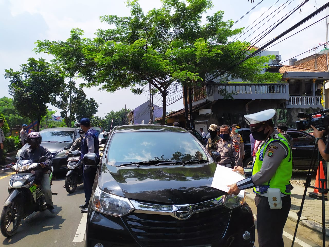 Petugas saat melakukan check point Sandratek kepada para pengendara di Jalan Ir. H. Juanda, Ciputat Timur, Tangsel, Sabtu (18/4/2020).