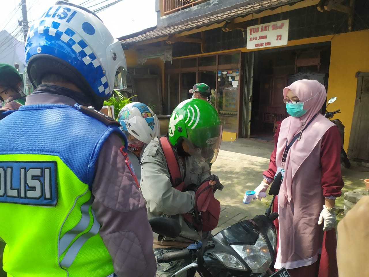 Petugas saat melakukan check point Sandratek kepada para pengendara di Jalan Ir. H. Juanda, Ciputat Timur, Tangsel, Sabtu (18/4/2020).