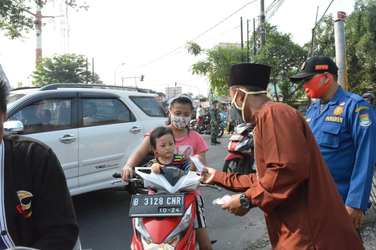 Para Guru Ponpes Daarul Muttaqien saat membagikan Masker ke pedagang asongan di simpang Tiga Cadas, Kecamatan Sepatan, Kabupaten Tangerang, Senin (21/4/2020).