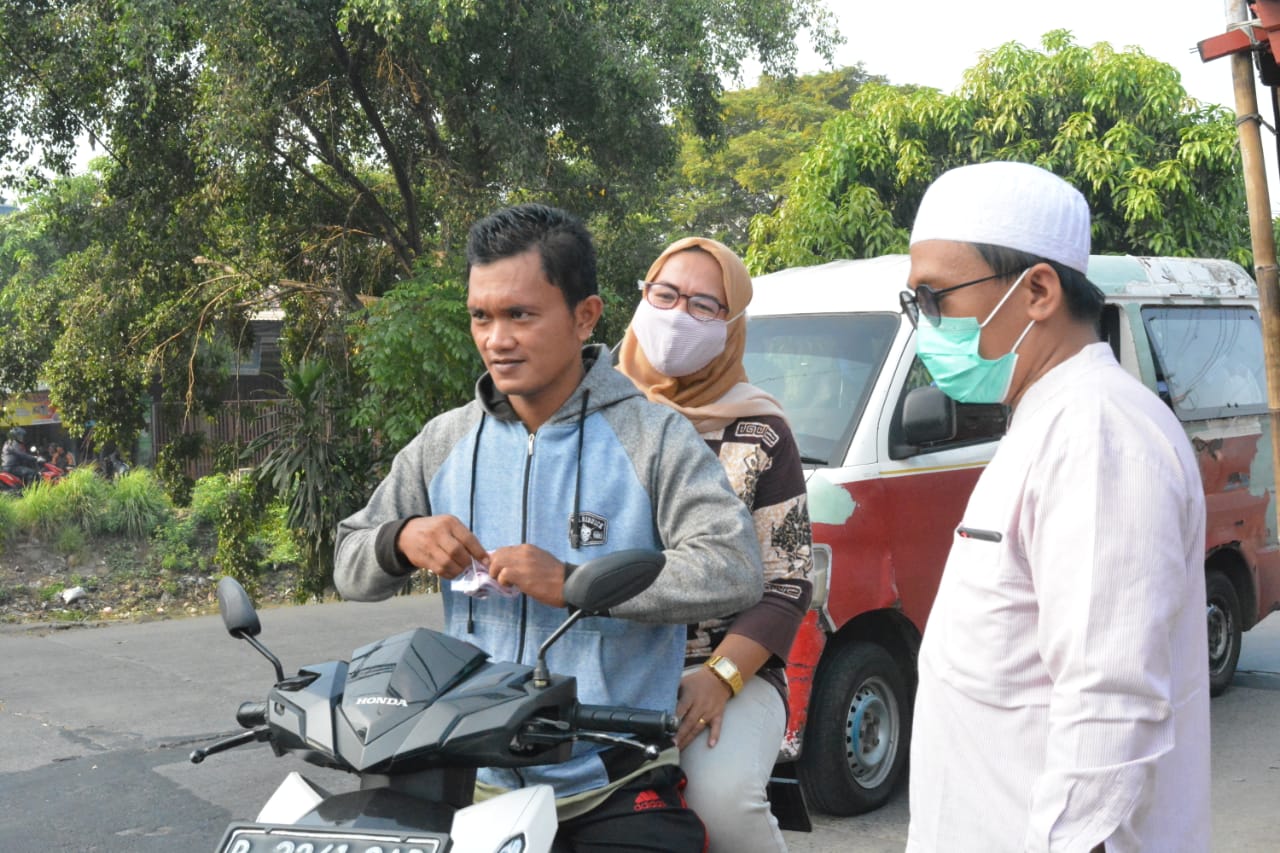 Para Guru Ponpes Daarul Muttaqien saat membagikan Masker ke pedagang asongan di simpang Tiga Cadas, Kecamatan Sepatan, Kabupaten Tangerang, Senin (21/4/2020).