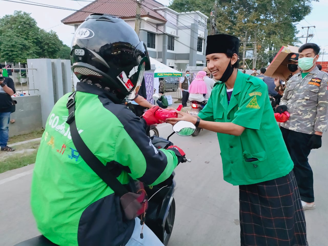 Aksi sosial Gerakan Pemuda Ansor Curug membagikan masker kepada pengendara yang melintas di Jalan PLP Curug, Minggu (3/5/2020).