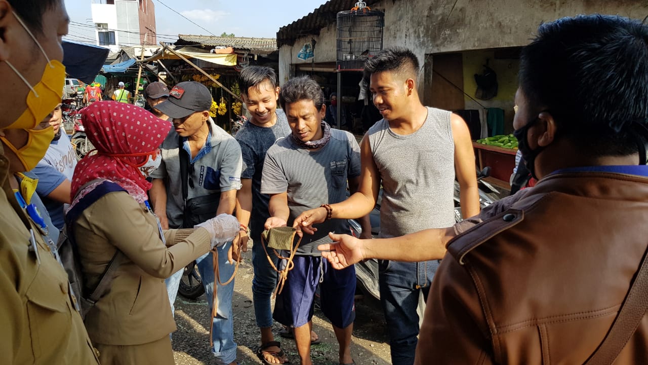 Petugas memasang tirai plastik di lapak-lapak pedagang di pasar tradisional Kota Tangerang, Selasa (5/5/2020).