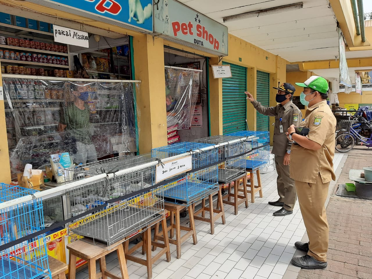 Petugas memasang tirai plastik di lapak-lapak pedagang di pasar tradisional Kota Tangerang, Selasa (5/5/2020).