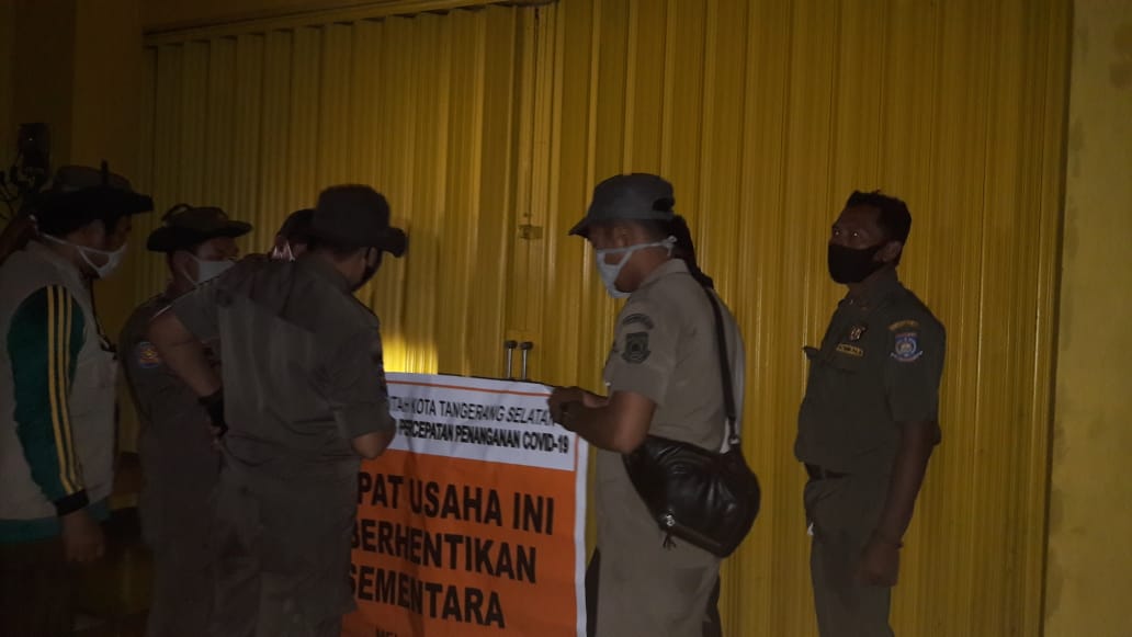 Anggota Satpol PP Kota Tangsel saat menyegel salah satu toko yang melanggar peraturan PSBB, Jumat (8/5/2020).