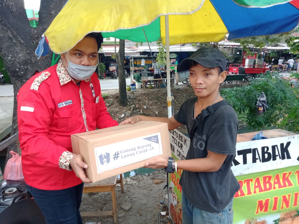 Pengurus DPC GMNI Kota Tangerang menyerahkan paket sembako kepada pelaku UMKM di Kota Tangerang.