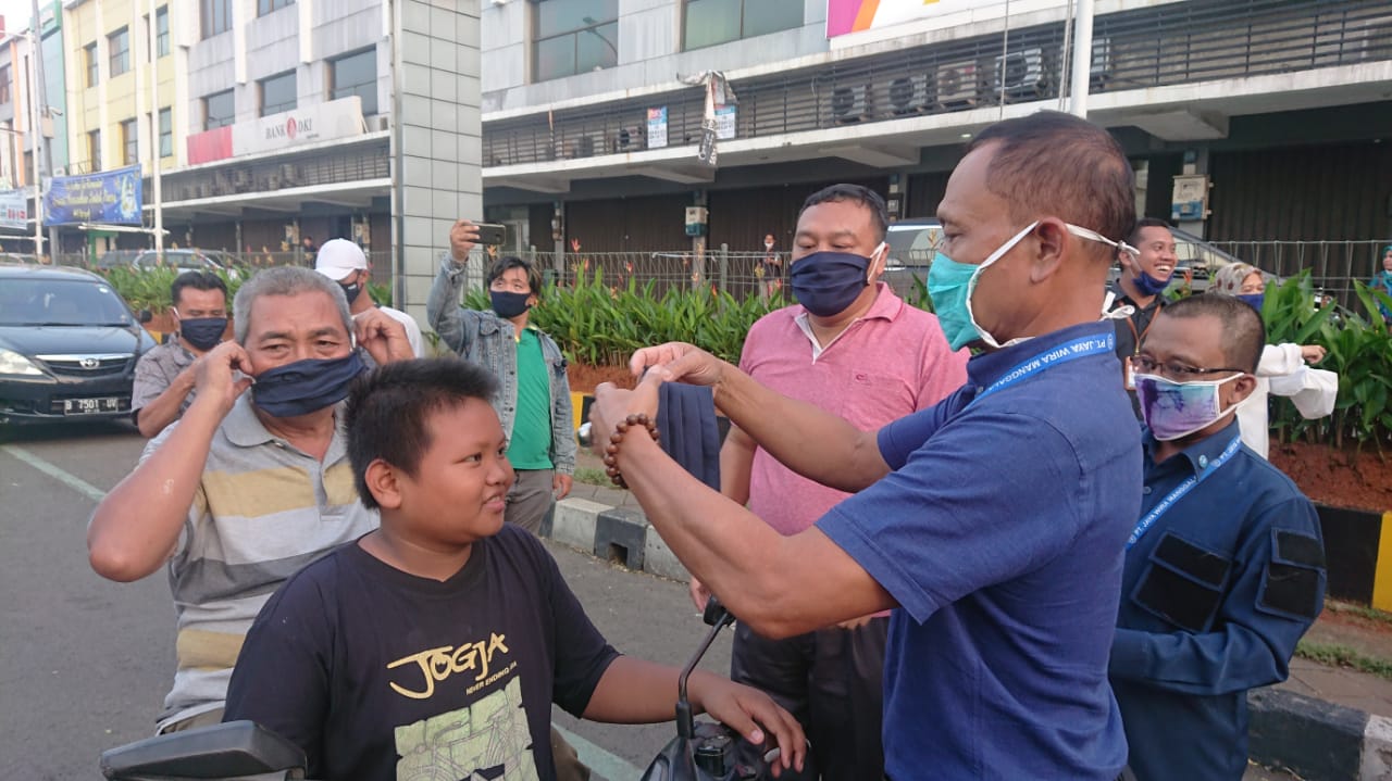Warga saat diberikan masker dari PT Jaya Wira Manggala Tangerang di Jalan Perintis Kemerdekaan, Cikokol, Kota Tangerang, Kamis (14/5/2020).