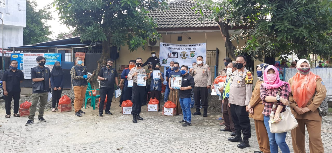 Salah satu seorang komunitas Harley Davidson B'Brothers menyerahkan paket sembako kepada warga Pondok Kacang Barat, Pondok Aren dan di dampingi Polres Tangsel, Tangerang Selatan, Selasa (19/5/2020).