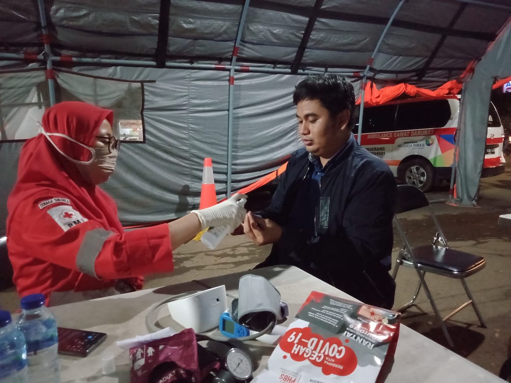 Personel PMI sedang melakukan pemeriksaan cek suhu dan tekanan darah kepada warga yang ingin mudik, Kota Tangerang, Selasa (19/5/2020).