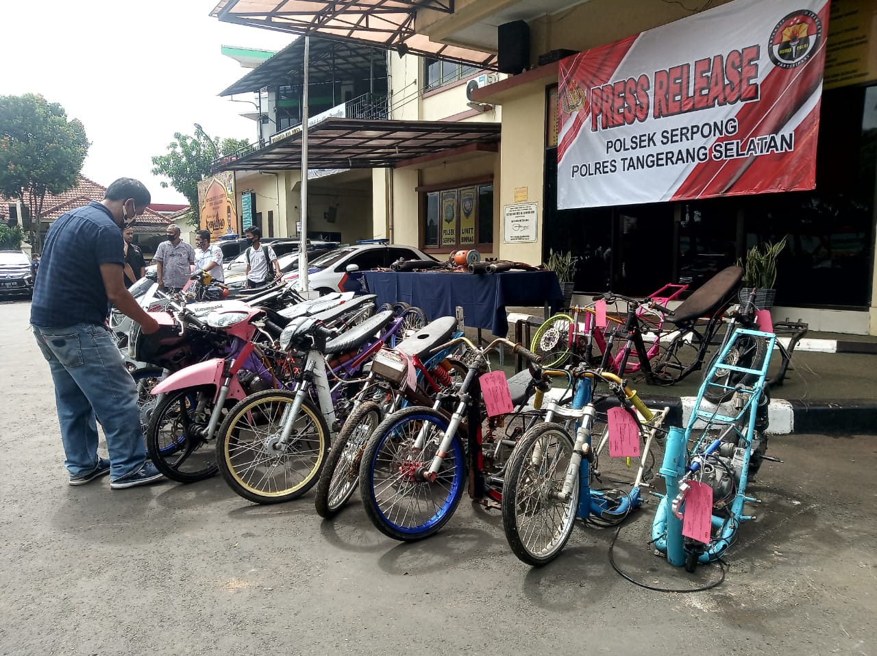 Angota Polsek Serpong dan TNI memegang barang bukti sperpat motor yang di gunakan saat balap liar, Serpong Utara, Tangerang Selatan, Kamis (21/5/2020).