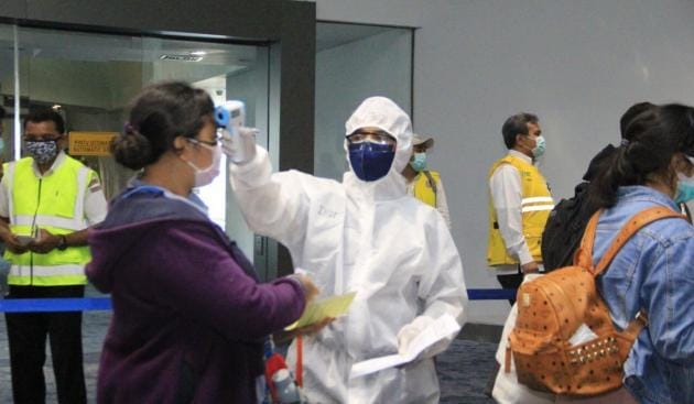 Petugas mengecek suhu tubuh pengunjung saat WNI tiba di Bandara Soekarno-Hatta.